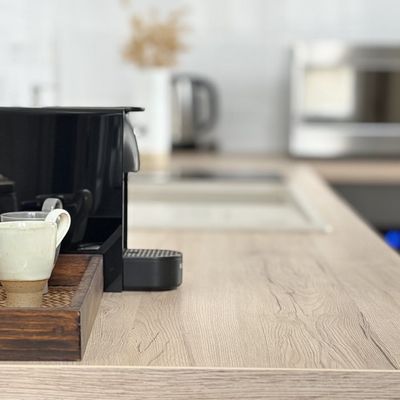 Machine à café Nespresso et tasse artisanale sur plateau en rotin