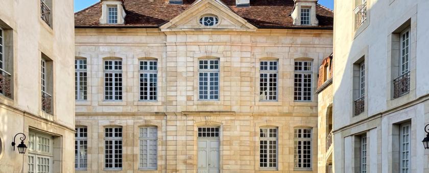 Façade en pierre de l'hôtel particulier du XVIIIe siècle de Maison Jazey, vue depuis la cour d'honneur pavée