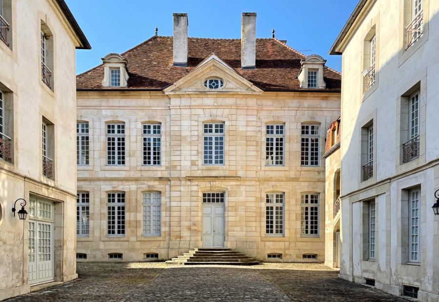 Façade en pierre de l'hôtel particulier du XVIIIe siècle de Maison Jazey, vue depuis la cour d'honneur pavée