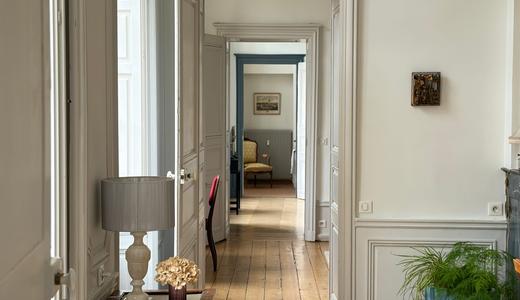 Enfilade de pièces avec boiseries blanches, parquet de chêne et lumière naturelle