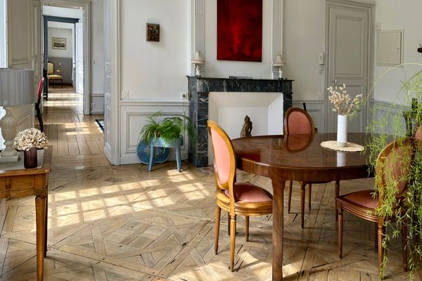 Enfilade avec cheminée, miroir doré et parquet en chevrons