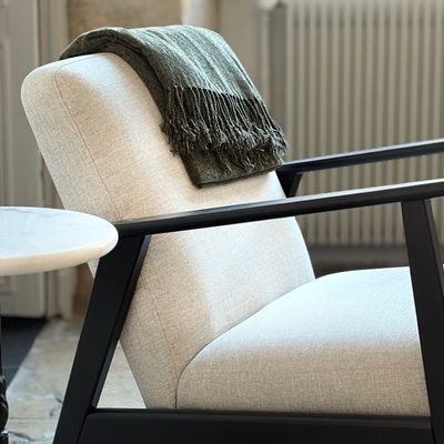 Fauteuil design avec plaid en lin et table ronde en marbre
