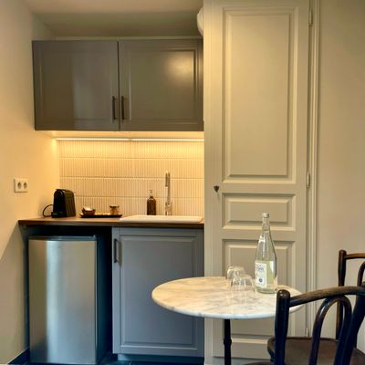 Kitchenette équipée avec table bistrot en marbre et machine à café
