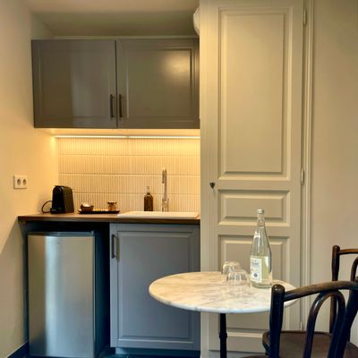 Kitchenette équipée avec table bistrot en marbre et machine à café