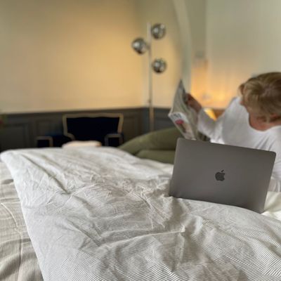 Lecture au lit avec laptop et lumière tamisée du soir