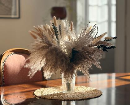 Bouquet de pampas séchées sur table en marqueterie dans une salle à manger