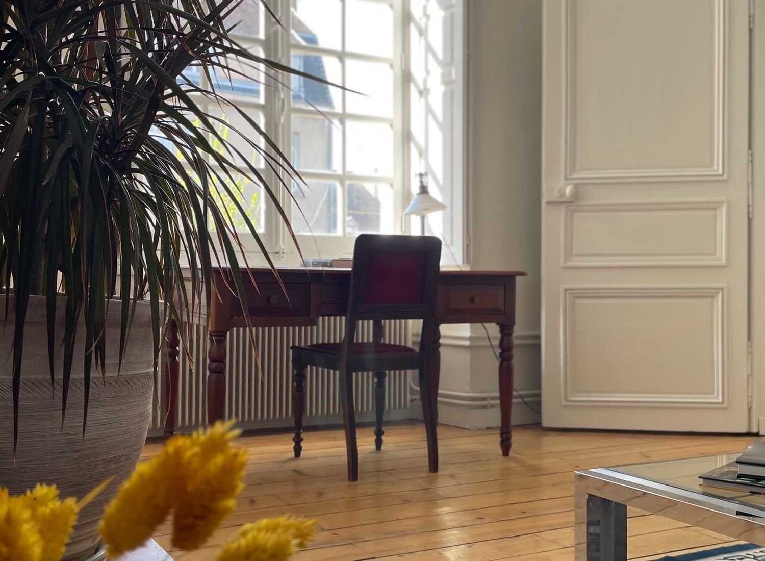Bureau d'époque face à la fenêtre de la Suite Côté Jardin, tapis persan et lumière douce