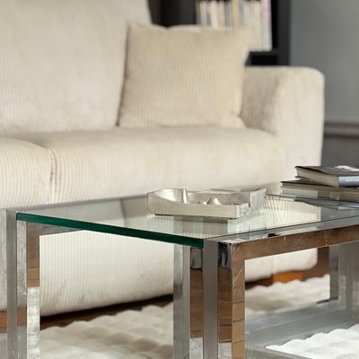 Table basse en verre et livres d'art dans le salon de la Suite Côté Jardin