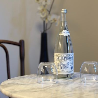 Bouteille d'eau Velleminfroy et verres sur table en marbre blanc