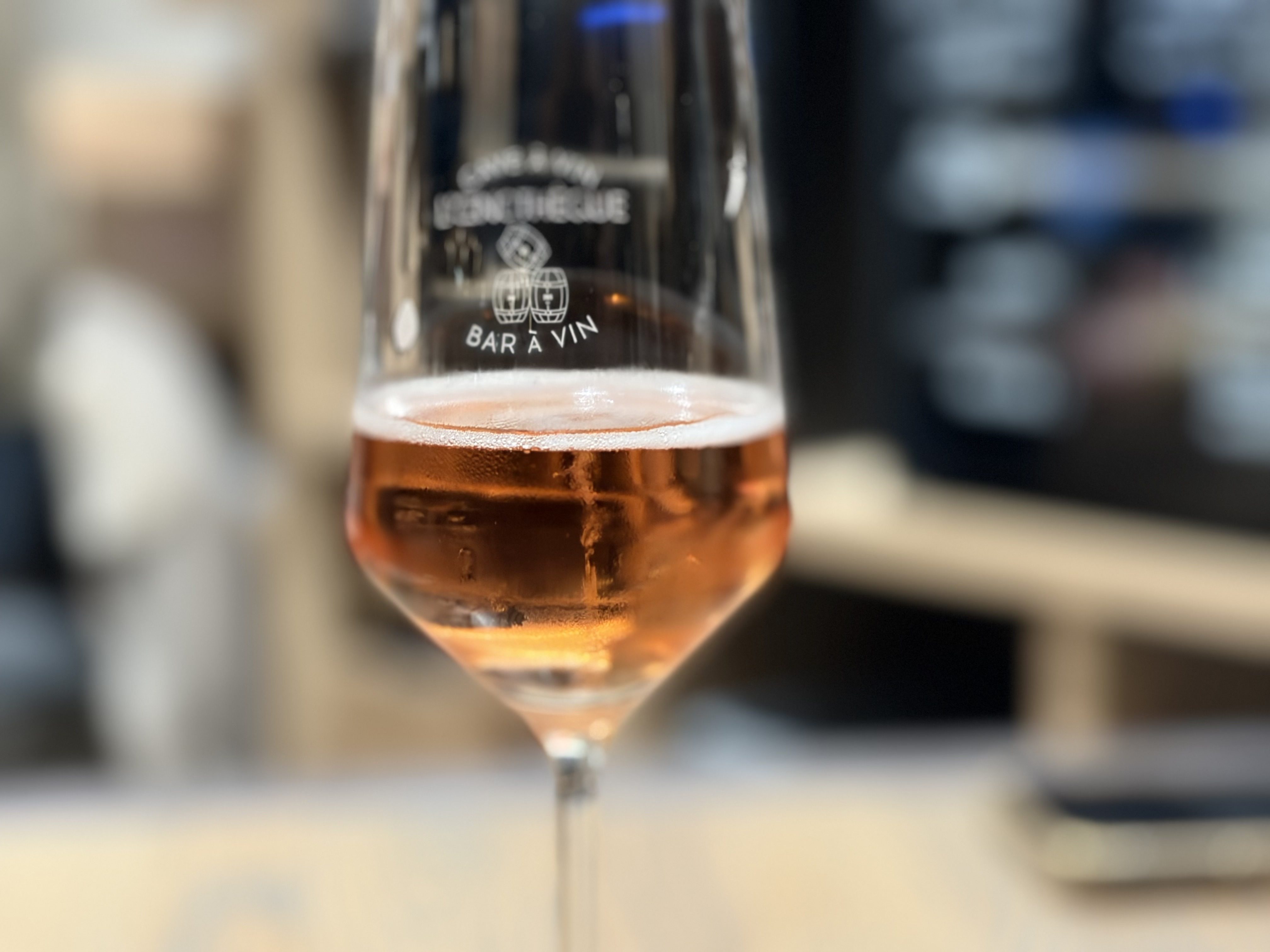 Verre à vin gravé au logo Bar à vin Oenothèque avec rosé servi au comptoir