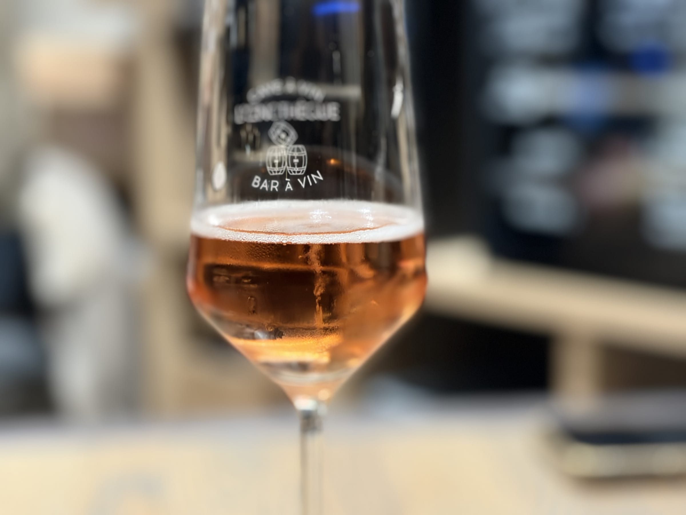 Verre à vin gravé au logo Bar à vin Oenothèque avec rosé servi au comptoir
